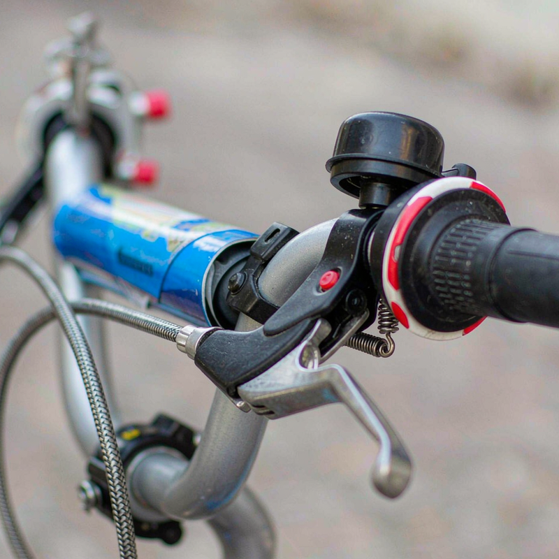 Close-up of a child's bicycle handlebar with small hand brake lever and grips