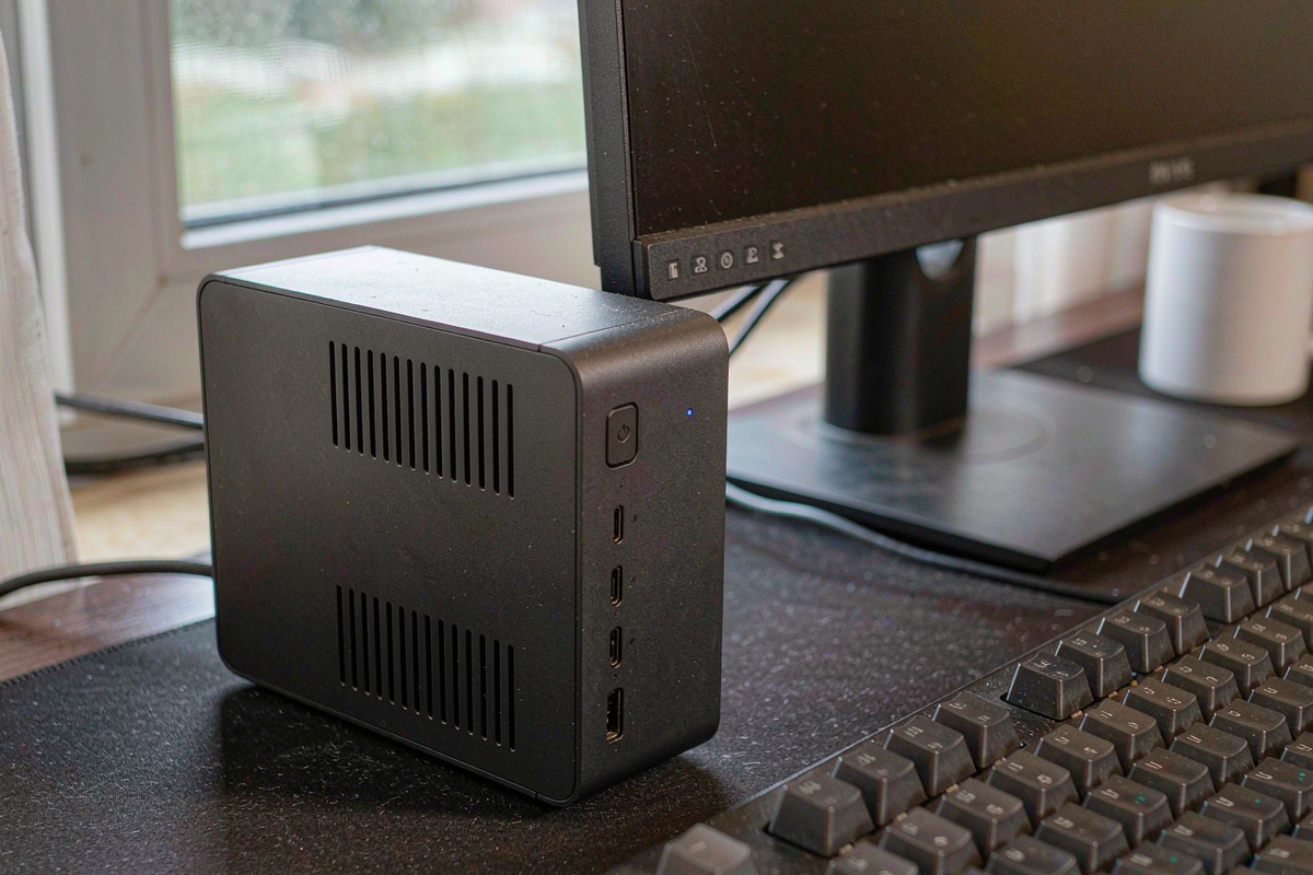 Getorli GT105 black mini PC on a desk beside a 4K monitor