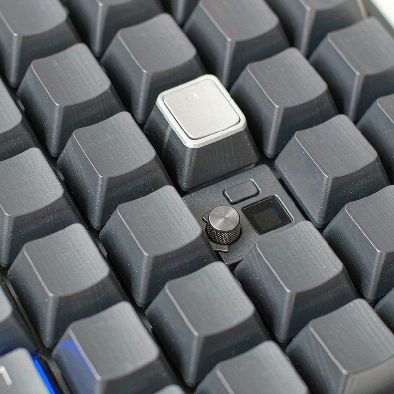 Macro view of the rotary knob and small colour display in the corner of the K719 PRO.